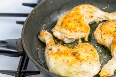 Bacaklar baharatlar ile bir tavada kızartma tavuk