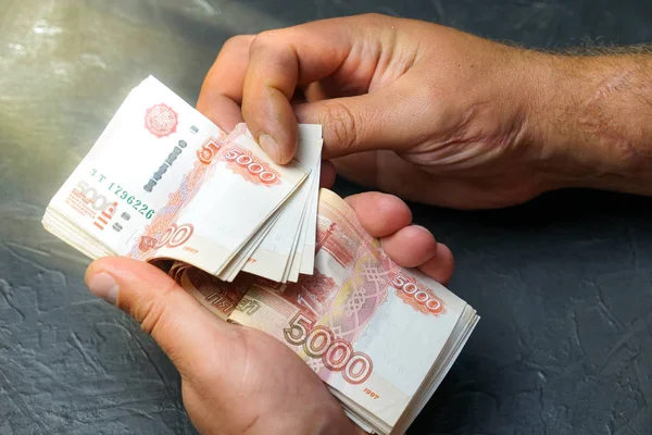 Bir adam bir banknot 5000 ruble bulur. Metniniz için yer