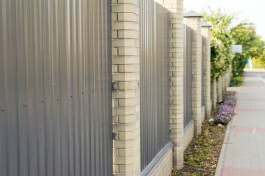 Tuğla sütun içeren metal çit özel alan