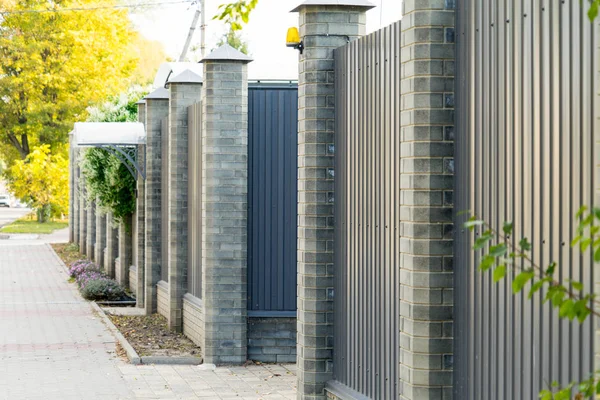 Tuğla sütun içeren metal çit özel alan