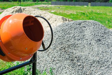 Fotoğraf Beton Mikser kum ve çakıl yığını yanında inşaat alanına yüklü.