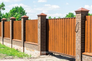Tuğla sütun içeren metal çit özel alan.
