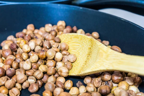 fry hazelnuts in a frying pan. fresh nuts in the pan.