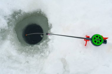 Balık tutma kış. Buzdaki delik yanında kış olta