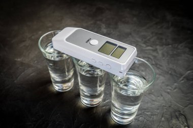 bir cam içinde breathalyzer ve alkol. karanlık bir arka planda fotoğraf.