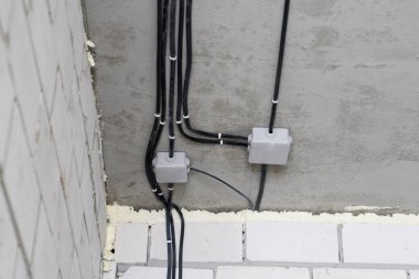 Bir tuğla evde elektrik kablolama imalatı.