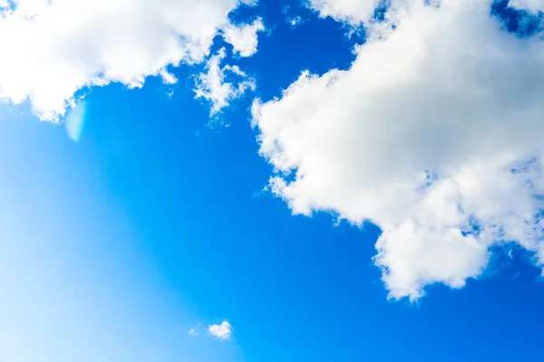 Beyaz bulutlar ile mavi güneşli gökyüzü fotoğrafı. — Stok fotoğraf