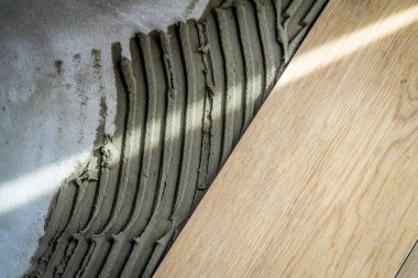 Özel bir tutkal ile yere fayans döşeme.