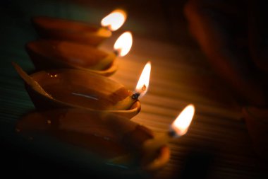 Geleneksel toprak lambaları, Diwali festivali vesilesiyle renkli rangoli (toz) tasarımları ile güzel bir desen içinde dizilmiş.
