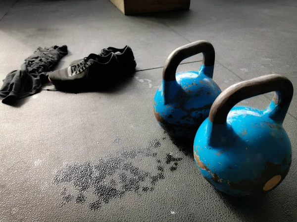 İki Kettlebells, Ayakkabı ve Sweaty Gömlek Sert Bir Egzersiz sonra