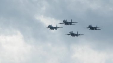 Askeri bir uçak fuarında dört adet su35 uçağı ağır çekimde havada uçuyor.