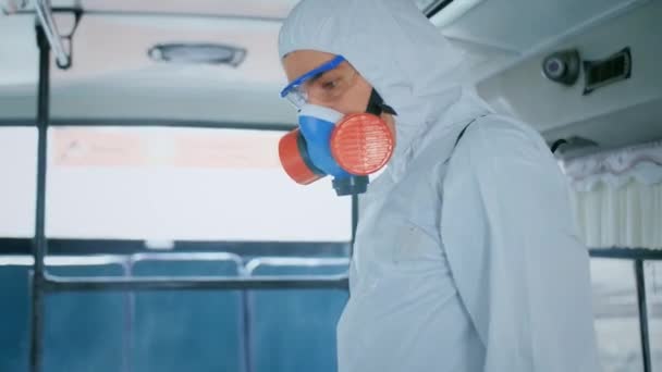 Desinfector in beschermingspak. Desinfectie in het openbaar stedelijk vervoer. Bus. — Stockvideo