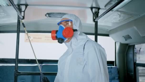 Disinfettante in tuta protettiva. Disinfezione all'interno dei trasporti pubblici urbani. Autobus . — Video Stock