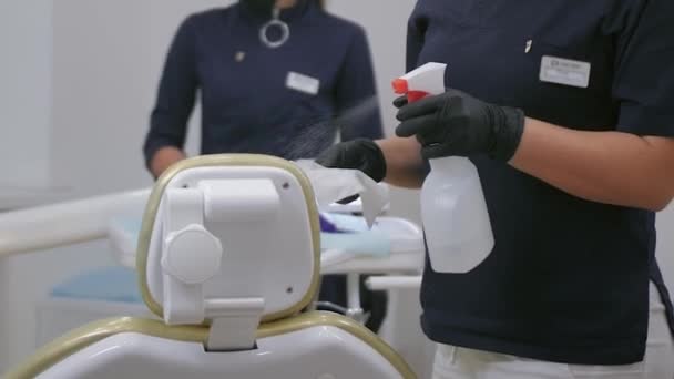 Las mujeres desinfectan la mesa del dentista por desinfectante y desinfectan la habitación con coronavirus — Vídeo de stock