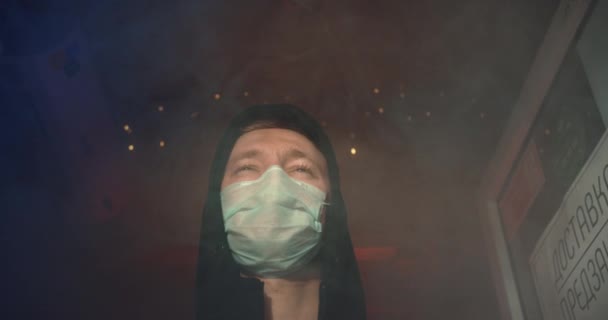 Человек в маске стоит в опасности и дезинфицирует дым после пожара. Коронный вирус covid-19 4K . — стоковое видео