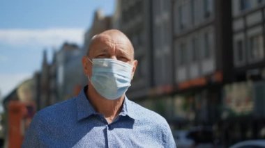 Gerçek bir yaşlı adam maskesi yürüyüşü. Kıdemli kişi Covid-19 'a karşı koruma sağlıyor. Coronavirüs