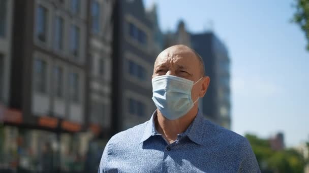Emekli insan maskesi dışarıda yürüyor. Kıdemli adam Covid-19 Coronavirus 'a karşı korur. — Stok video
