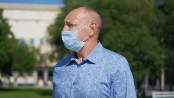 Farföräldern andas frisk luft i parken bära mask medan Covid19 farligt. Människor — Stockvideo