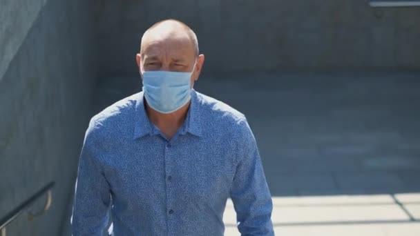 コロナウイルスを恐れている年金受給者は、空の通りを歩く医療マスクを着用してください。コヴィド — ストック動画