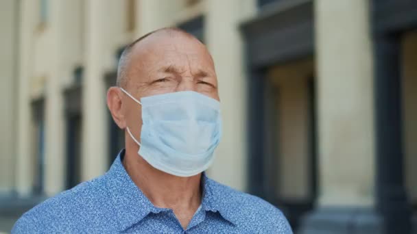 Sorglig man rynkor mask ser ut kamera. En pandemisk person. Coronavirus. Personporträtt — Stockvideo