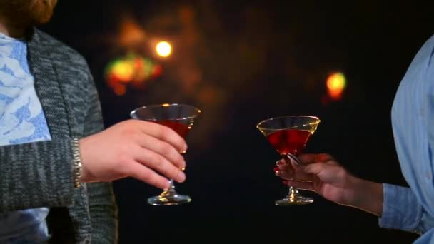 To kærlige mennesker closeup banke briller rødvin på dato med farverigt fyrværkeri. – Stock-video