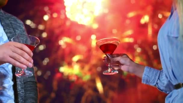Liebespaar klopft Gläser Wein Nahaufnahme auf Hintergrund Feuerwerk in der Nacht Date — Stockvideo