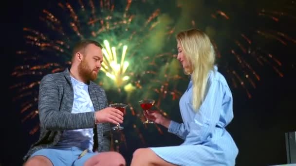 Романтична пара на побаченні насолоджується феєрверками в нічному небі робить тост скляним червоним вином — стокове відео