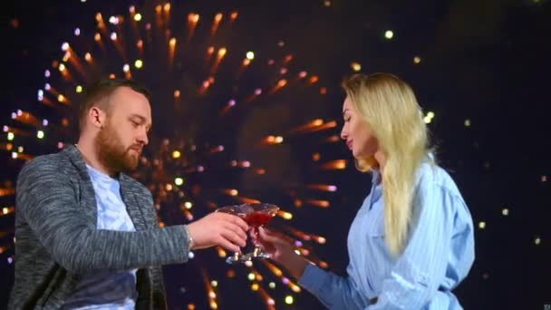 Dos personas cariñosas celebrando copas de vino en la fecha con fuegos artificiales de colores. — Vídeos de Stock