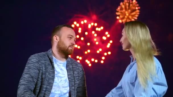 Romantic couple kissing in night date on background fireworks celebrate weekend. — Stock Video