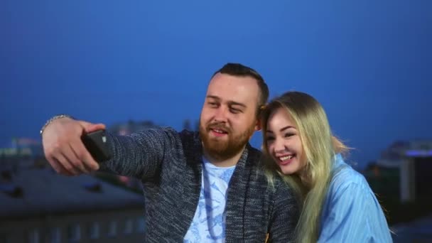 幸せなロマンチックな愛のカップル作る自撮り上の携帯電話の背景ナイトシティライト｜4K — ストック動画