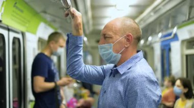 Covid-19 maskeli yaşlı adam metroda Coronavirus 'suz insan kalabalığının içinde..