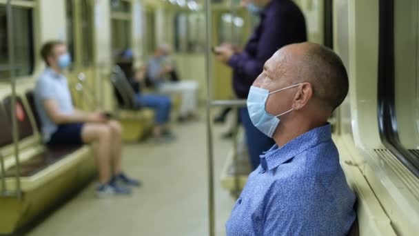 Emeryci i mężczyzna w masce w metrze chronią się przed wirusem korony, Covid-19 — Wideo stockowe