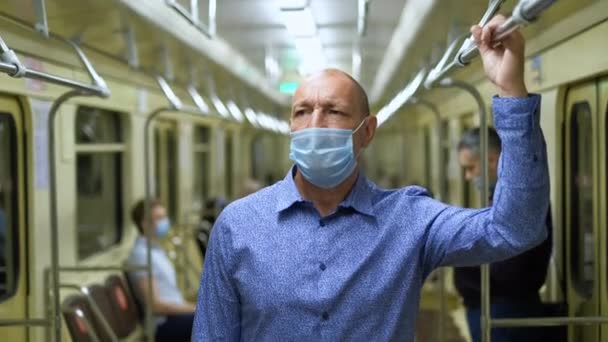 老年人在地铁里戴口罩，男人不会感染日冕病毒，Covid-19在地铁里. — 图库视频影像