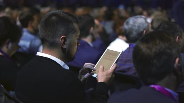 Estudante lotado público digitando tablet texto palestra faculdade. Homem use touch pad. — Vídeo de Stock