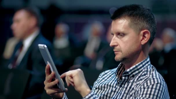 Usando el visor de multitudes del auditorio de la conferencia del bloc de notas. Hombres de negocios tipo finger pad. — Vídeo de stock