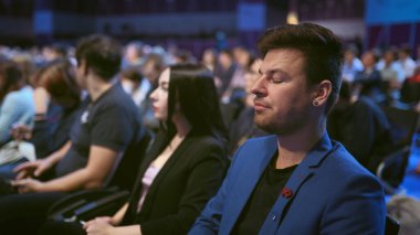 İnsanlar kalabalık seyircileri esnetir. Ekonomik forumda uyuyan bir iş adamı. Sıkıcı ders.