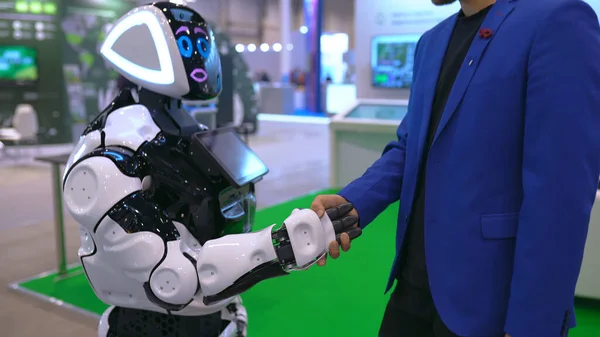 Les gens saluent cyborg poignée de main en signe amitié future 4K. Rencontrez des amis technologiques. Photo De Stock