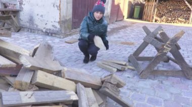 Kadın bir kenara atasın yakacak odun yığını içinde