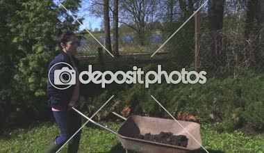 Bahçede kadın iterek el arabası