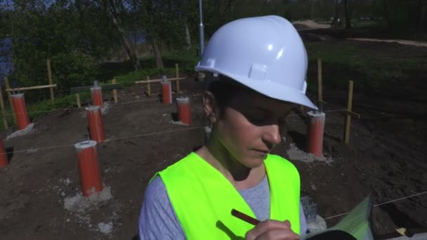 Mujer Sostiene Casco Escritura Cerca Del Sitio Construcción — Vídeo de stock