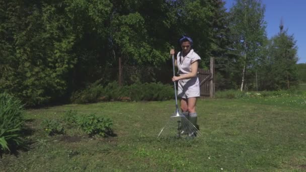 Frau Mit Harke Sammelt Das Gras Auf Der Wiese — Stockvideo