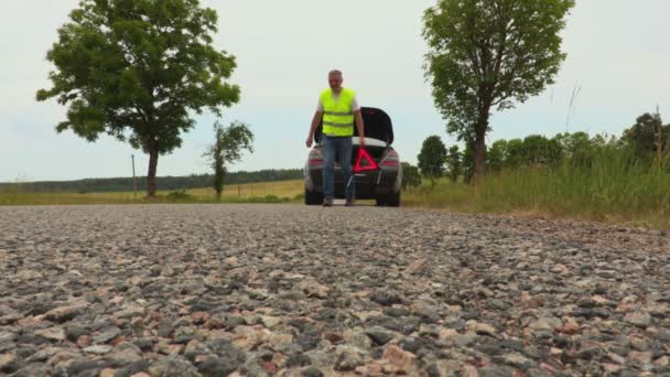 男を警告の三角形をつける車の近くの道路 — ストック動画