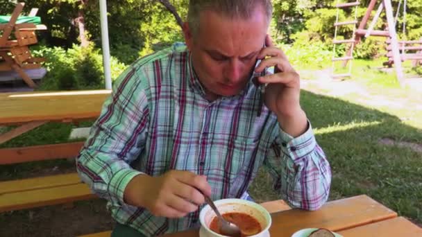 Homem Comendo Sopa Falando Telefone — Vídeo de Stock