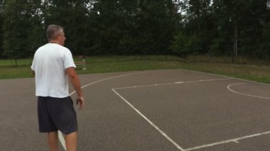 Kamera adam basketbol topu ile takip eder.