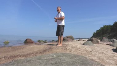 Adam denizin kenarında yaz günde taş atan