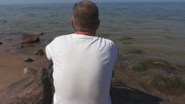 Deniz taş üzerine oturan adam 