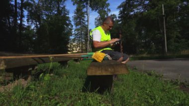 İşçi parkta bankta tablet kullanma