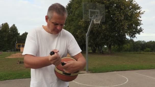 Mann Pumpt Basketball Ball — Stockvideo