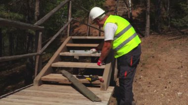 İşçi merdivenlerden düzeyini denetler