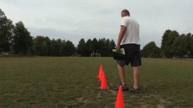 Koç kırmızı koniler futbol sahasında yerleştirir.